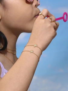 Close-up of child wearing colorful unicorn bracelets and rings in a sunny setting