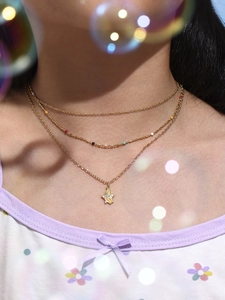 Close-up of triple-layered gold necklace set with unicorn star pendant and colorful beads