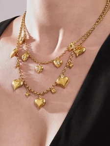 Detail of 18k gold plated stainless steel layered necklace with heart and M letter pendants