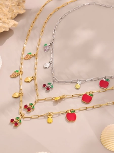 Detalle de collares de frutas en oro y plata con colgantes de cereza, manzana y piña