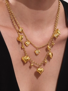 Close-up of a double-layered 18k gold-plated heart necklace with M and A zircon letters