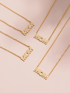 Detail van vier gouden MOM-kettingen met pavé-zetting op een zachte roze achtergrond