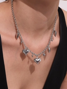 Close-up of a silver multi-heart pendant necklace worn by a model on a black V-neck top
