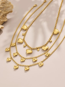 Detailed view of gold plated necklaces with heart pendants and sparkling M and A letters