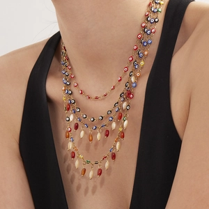 Gelaagde gouden evil eye ketting met kleurrijke agaat kralen en levendige kwastjes details