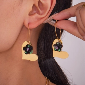Boucles d'oreilles cœur vintage avec fleurs en résine noire portées par un mannequin