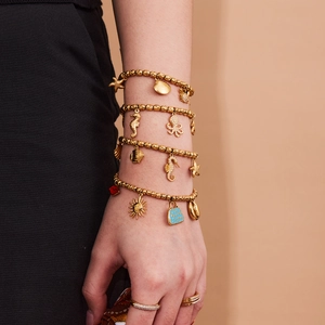 Set de pulsera dorada con elementos marinos como caballito, estrella de mar y esmalte azul