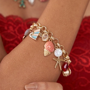 Close-up of gold charm bracelet with shell, starfish and colorful enamel sea creatures