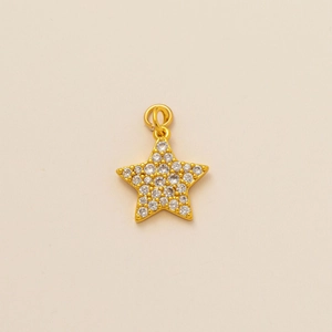 Détail d'un pendentif étoile dorée avec pavage de pierres en zircone cubique scintillantes