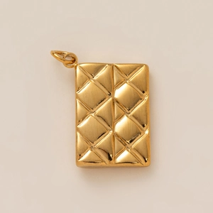 Close-up of golden rectangular charm featuring classic quilted texture and high-gloss finish
