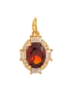 Macro detail of oval red birthstone pendant with white zircon halo in gold plated brass