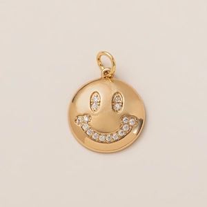 Macro detail of 18K gold plated round smiley face pendant with sparkling white zirconia