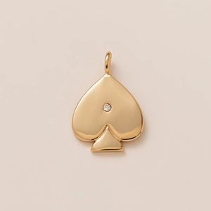Detailed view of polished 18K gold spade pendant featuring a sparkling crystal center