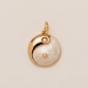 Macro view of 18K gold Yin Yang pendant with white pearl and mother of pearl texture