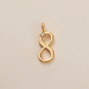 Détail d'un pendentif chiffre huit doré orné d'une petite pierre de zircone scintillante