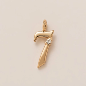 Macro shot of 18K gold-plated number seven pendant with a sparkling white zircon stone