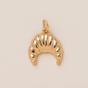 Detailed macro view of a 18K gold plated croissant pendant with a high polished mirror finish