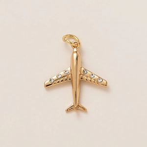 Detailed view of an 18K gold-plated airplane pendant with sparkling inlaid rhinestones
