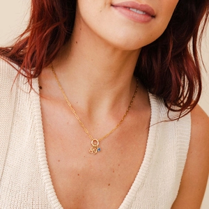 Detail of 18K gold plated paperclip chain with number 89 and blue gemstone pendant