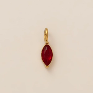 Close-up of a marquise-cut red gemstone pendant set in a polished gold plated metal frame