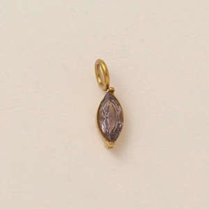Macro shot of marquise-cut lavender stone pendant in vintage gold-plated frame