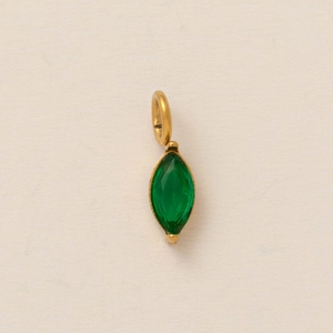 Marquise-cut green gemstone pendant with a gold-tone bail on cream textured paper