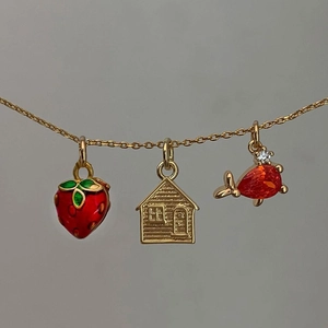 Gold chain necklace with red strawberry, golden house, and orange pear drop pendants