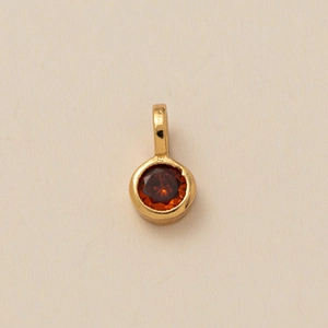 Golden hexagon necklace with round orange gemstone pendant and birthstone flower detail