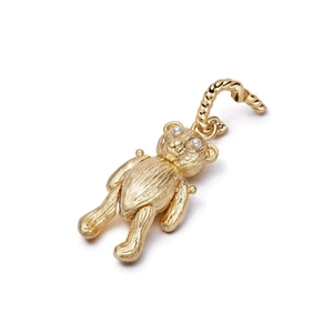 Macro shot of golden bear pendant with textured metal finish and movable joint limbs