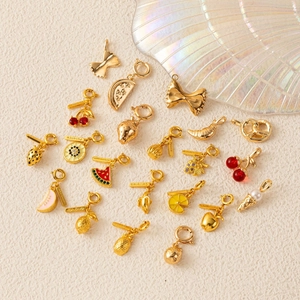 Pendentifs fruits dorés avec détails en émail et plaques gravées sur fond beige