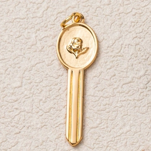 Detailed view of golden 18K gold-plated key pendant with embossed rose flower design