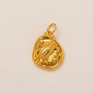 Macro view of gold owl coin pendant with high gloss finish and detailed embossing