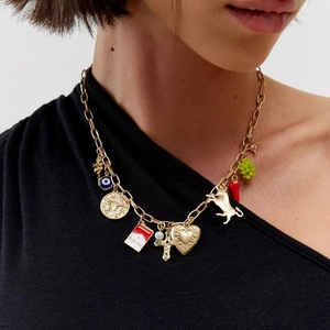 Western vintage multi-charm gold necklace with cross, heart and chili pendants on a model
