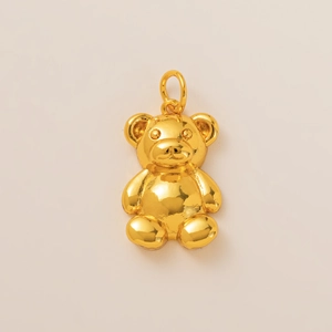 Macro shot of 3D teddy bear pendant in polished 18K gold plated metal texture