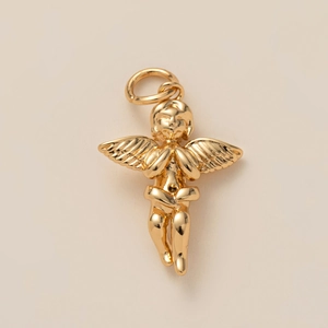 Détail d'un pendentif ange priant doré avec des ailes sur un fond beige neutre