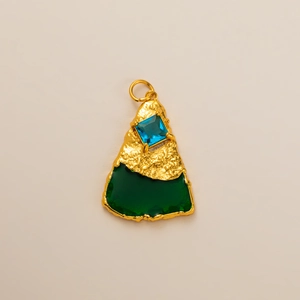 Detailed macro view of 18K gold irregular lava pendant with blue square gemstone and green inlay
