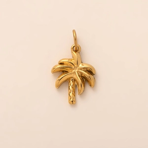 Dettaglio del ciondolo a forma di palma placcato oro 18k con texture tropicale curata