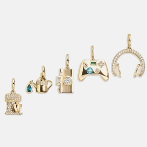 Set de cinco colgantes bañados en oro de 18K incluyendo cámara, mando y cascos