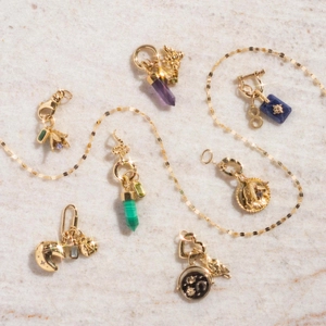 Collezione di ciondoli placcati in oro 18K con ape, serpente e stella su marmo bianco