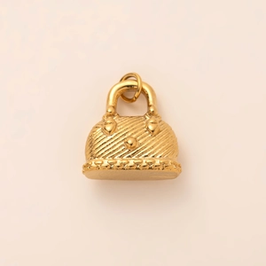Detail of 18K gold plated mini handbag pendant with textured twill and heart accents