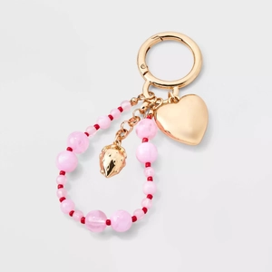 Detail of DIY keychain with gold heart, strawberry charms and pink beaded chain