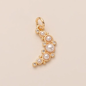 Vista macro de un colgante curvo bañado en oro de 14K con perlas y circonitas brillantes