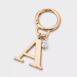 Detailed view of gold-plated letter A charm with white imitation pearls and spring clasp