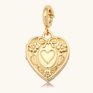 Détail du pendentif cœur plaqué or 18K avec relief floral et motif de nœud papillon