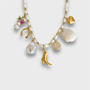 Collier en perles chic avec pendentifs dorés fer à cheval, botte, coquillage et cœur