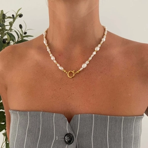 Detail van barokke parelketting met gouden veersluiting en 18k vergulde paperclip-schakels