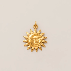 Détail d'un pendentif soleil et lune plaqué or 18 carats avec un motif mystique gravé