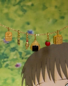 Detail of 18K gold plated ocean and food pendants including fish plaque and rice ball