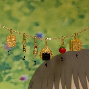Detailed close-up of 18K gold plated marine and food charms with delicate O-chain