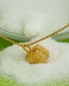 Macro view of golden gift box pendant with matte finish on stainless steel necklace